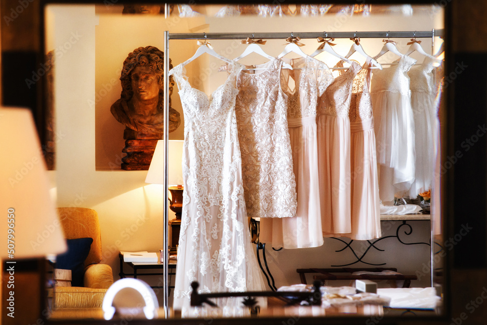 Wedding and bridesmaids dresses hanging on a metal hanger Wedding and bridesmaids dresses hanging on a metal hanger