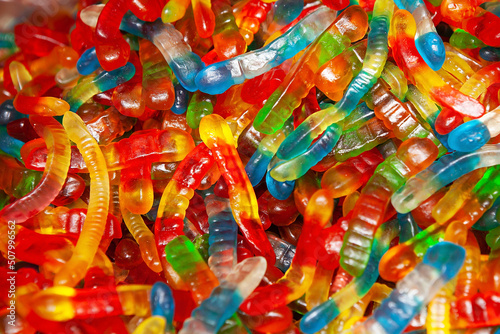 Candy sweets jelly. Close up view of delicious sweet candies in form of worms. Fruit jelly in shop window. Sweets for Easter, Halloween. Unhealthy or organic food. Selective focus. Top view