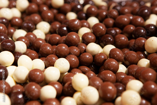 Candy chocolate sweets. Close up view of delicious chocolate round candies. Chocolate candys in shop window. Sweets for Easter, Halloween. Unhealthy or organic food. Selective focus 