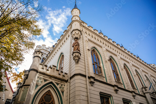 Riga, Latvia, 14 October 2021: Small Guild of St. John, Baltic states, Northern Gothic Style with arched windows and stone carvings, Facade of medieval buildings at sunny day, historic center