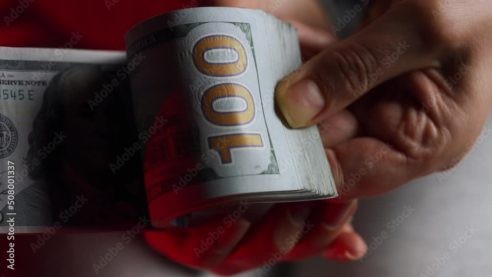 Hands checks US Dollar bills or counting in cash against the backdrop of police car lights Hands checks US Dollar bills or counting in cash against the backdrop of police car lights