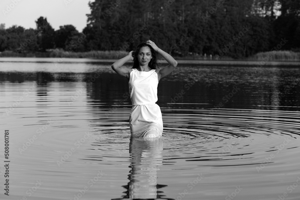 Young woman in dress in water in black and white Young woman in dress in water in black and white