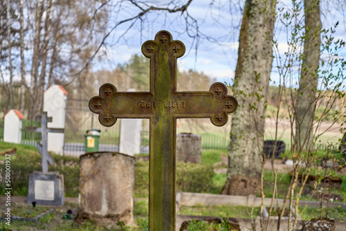Fotografie Ancient metal cross in the Latvian cemetery. Sunny day.