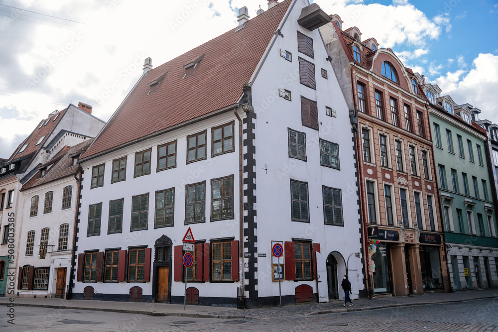 Riga, Latvia, 14 October 2021: Narrow picturesque street, Facade of colorful buildings in historic center of medieval city, renaissance and baroque houses at summer sunny day, cafe with wooden windows