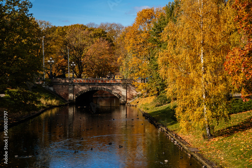 Riga, Latvia, 14 October 2021: Beautiful Bastejkalna Central Park with canals near the Latvian National Opera at autumn sunny day, bridge over water