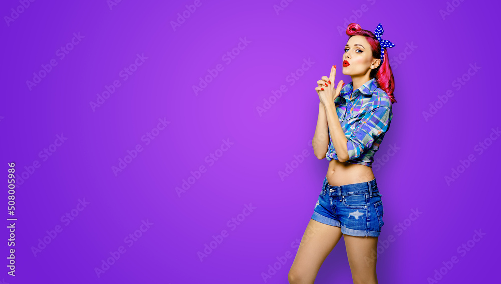 Pin up girl. Portrait of red purple attractive woman showing hand sign gesture. Retro and vintage concept. Violet background with copy space text area. Pinup female model pose at studio. Pin up girl. Portrait of red purple attractive woman showing hand sign gesture. Retro and vintage concept. Violet background with copy space text area. Pinup female model pose at studio.