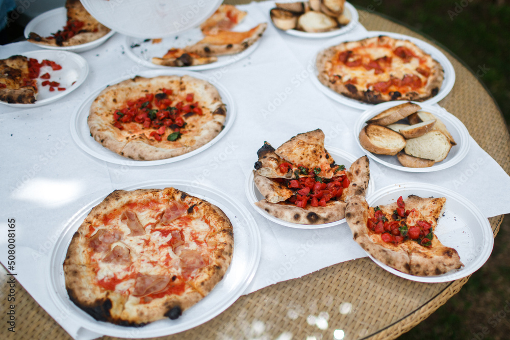 Pizzas on the table in plastic plates
