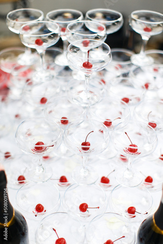 Pyramid of martini glasses with cherries on the wedding table
