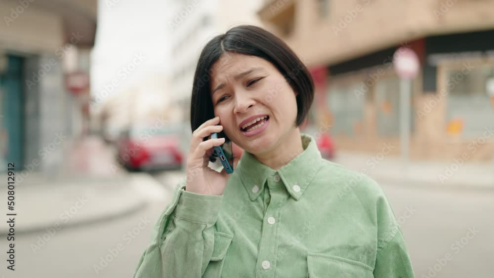 Young chinese woman smiling confident talking on the smartphone at street Young chinese woman smiling confident talking on the smartphone at street