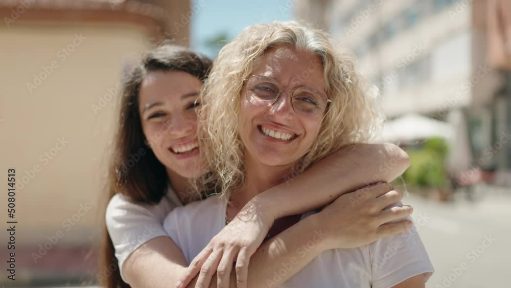 Two women mother and daughter hugging each other at street Two women mother and daughter hugging each other at street