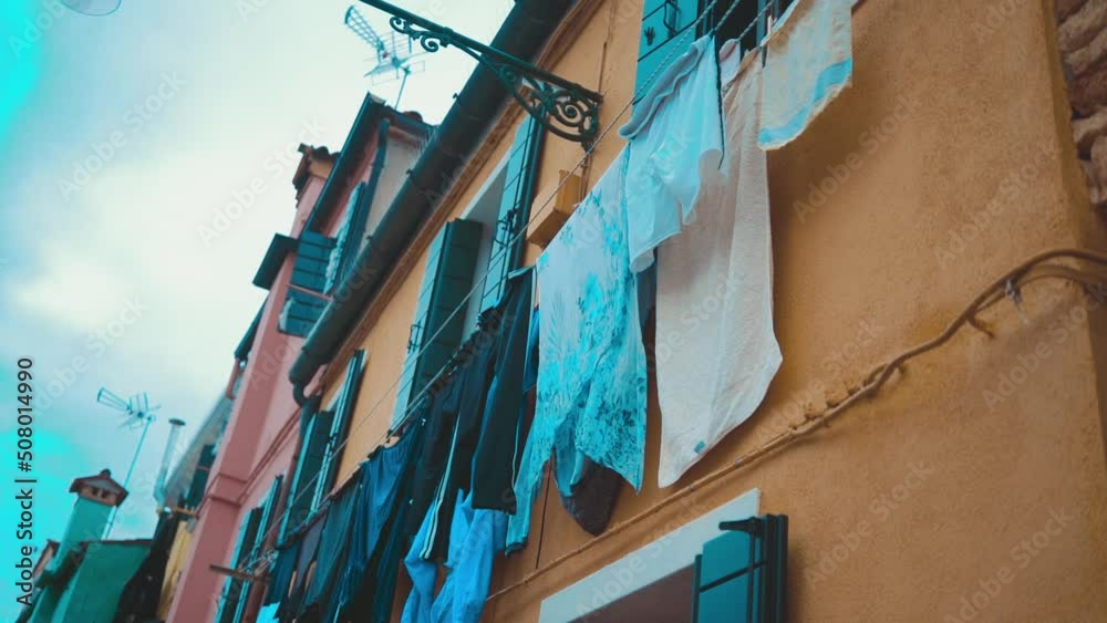 Clothes on clothesline outside. laundry drying outdoor at old italian street. Typical tourist place in Venetian lagoon Italy. Beautiful water canals and colorful architecture Burano Italy