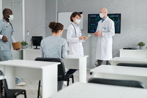 Group of interns entering in class for lecture with medical specialist meeting them