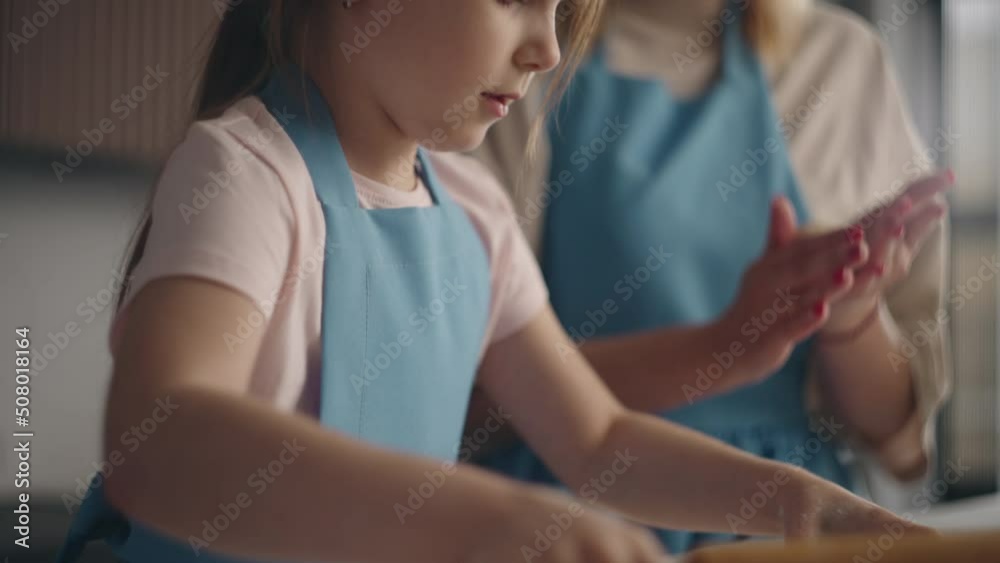 mother and her little daughter are cooking sweet buns in home kitchen in sunday, child is helping mother and her little daughter are cooking sweet buns in home kitchen in sunday, child is helping