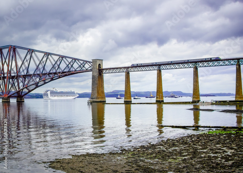 Southside of Forth bridge with a train passing over and liner through the arch © Alan