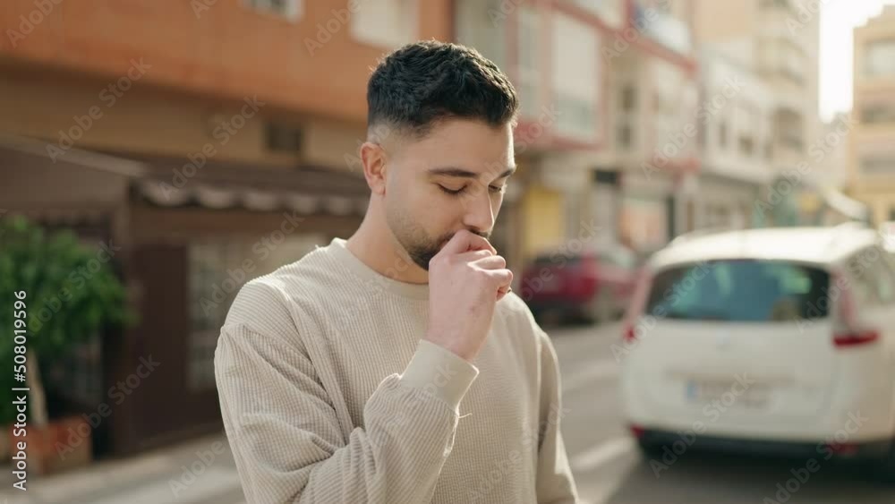 Young arab man smoking with relaxed expression at street