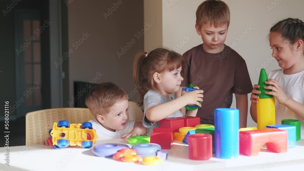 little boy and baby girl play in kindergarten. a group of children indoor play toys cubes and cars on the table in kindergarten. happy family preschool education concept. nursery baby toddler home little boy and baby girl play in kindergarten. a group of children indoor play toys cubes and cars on the table in kindergarten. happy family preschool education concept. nursery baby toddler home