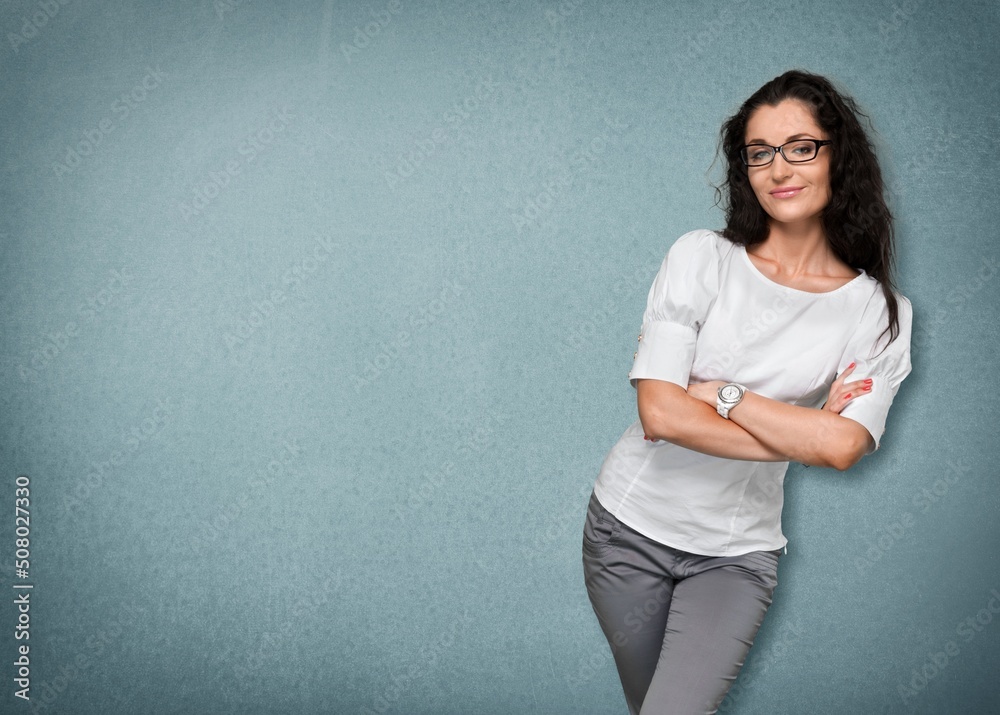 Young woman wearing apron on background. Woman with crossed arms on gray wall. Young woman wearing apron on background. Woman with crossed arms on gray wall.