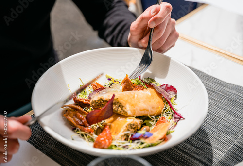 Fotografia Une personne mange un repas dans une assiette
