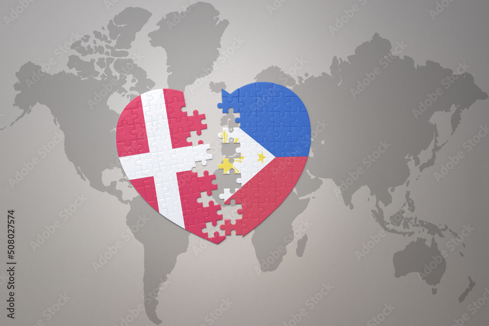 Fototapeta premium puzzle heart with the national flag of philippines and denmark on a world map background. Concept.