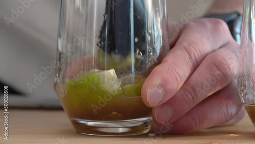 Man Mashing Lime On The Glass With A Muddler - Making Mojito. - close up photo