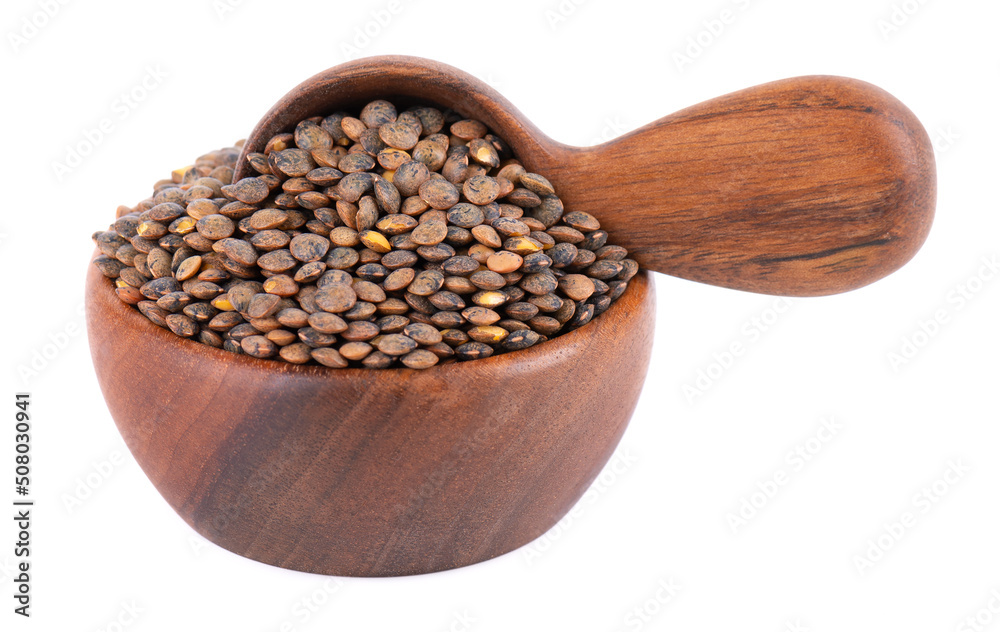 French lentils in wooden bowl and spoon, isolated on white background. Dry puy lentil grains pile. French lentils in wooden bowl and spoon, isolated on white background. Dry puy lentil grains pile.