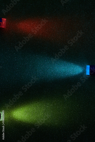 Parallel beams of red blue and yellow gradient light on a dark blue grungy background © andreyfire