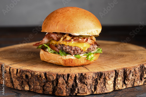 burger with meat, burger on a wooden table, juicy burger with different fillings