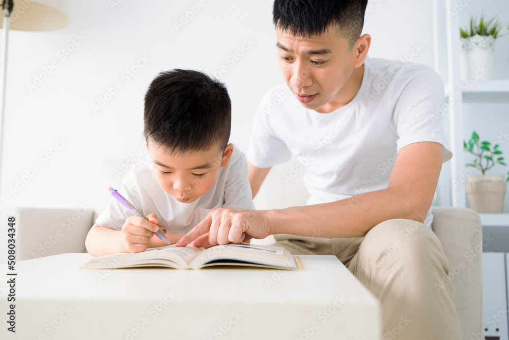 Father helping child doing homework at home Father helping child doing homework at home