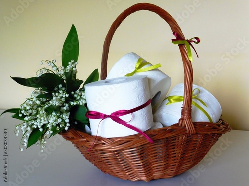 Toilet paper in a wicker basket. Toilet paper with the scent of lily of the valley.  © Mary
