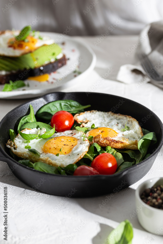 Breakfast with fried eggs and vegetables in a pan