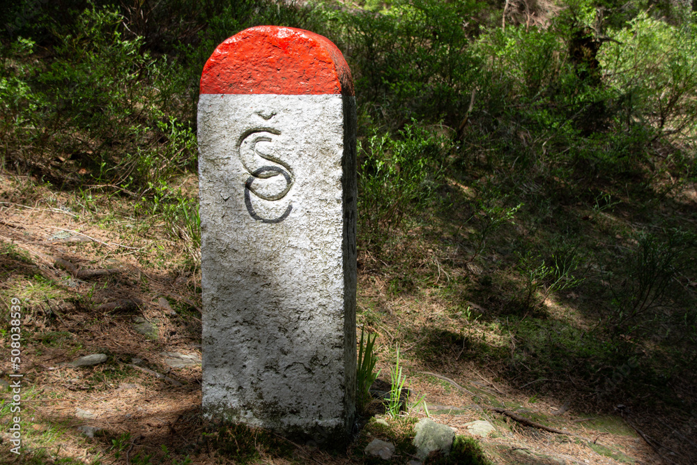 Stone pillar of the Czech border in a forest Stone pillar of the Czech border in a forest
