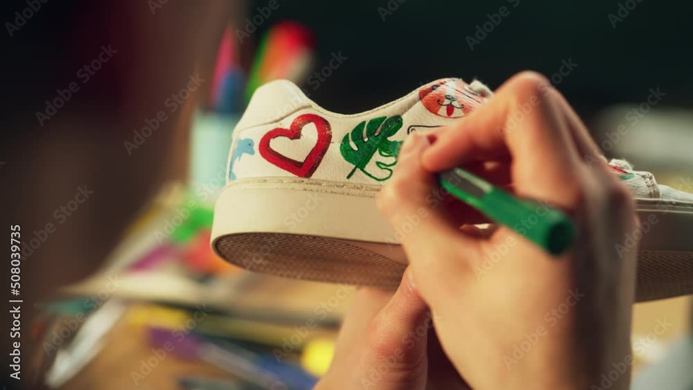 Shot of Artist Hand, Holding Marker and Drawing Design at the Shoes. Painter Creates Custom Made Sneaker and Make his Own Production. Millennial People and Startup Concept