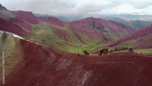 Wallpaper Mural Man in red walking with Lama (Alpaka) on Rainbow Mountain Peak at Vinicunca Valley in Peru. Aerial footage. Red Valley. Torontodigital.ca