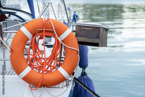 Orange life buoy attached to a yacht. Water rescue equipment.