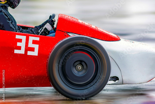Fotótapéta Racing cart in selective focus driving on an empty wet rainy road or track at high speed - motion blur