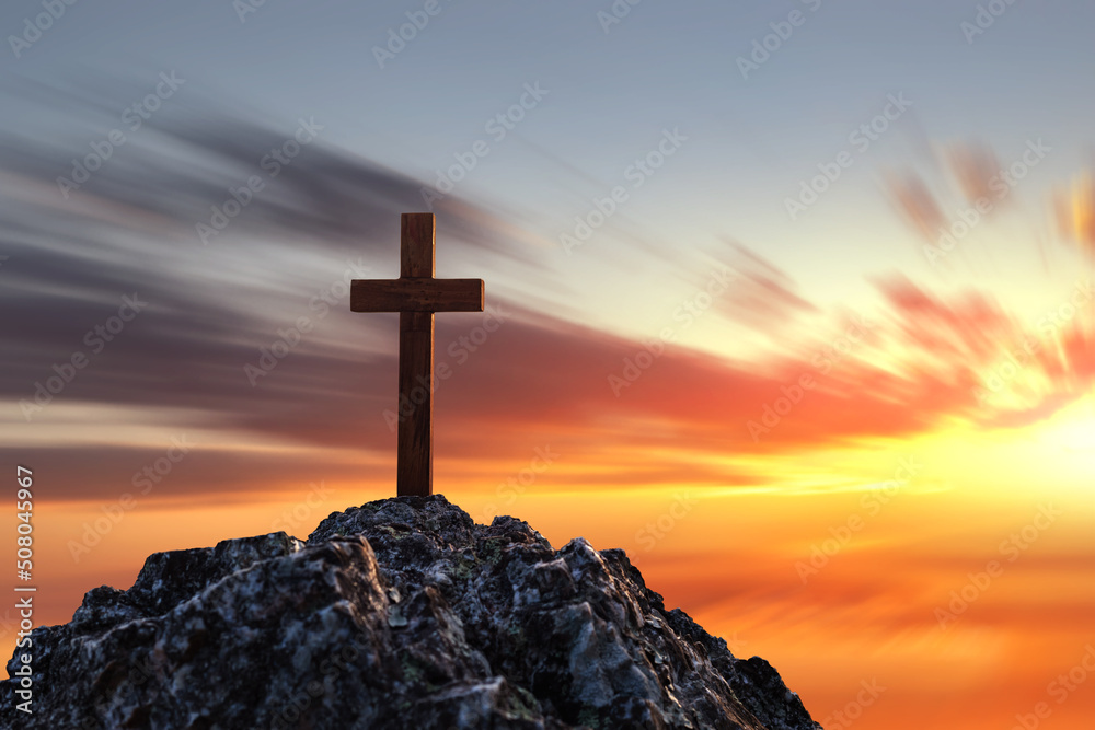 Silhouettes of crucifix symbol on top mountain with bright sunbeam on the colorful sky background