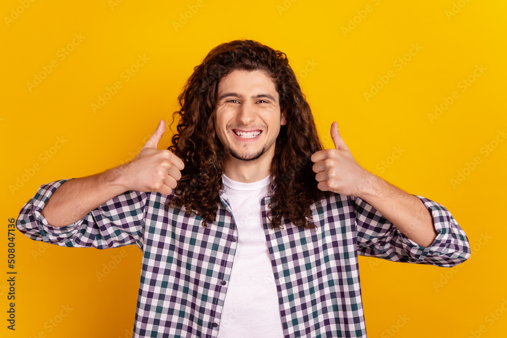 Photo of young cheerful guy show thumbs-up advertise choose recommend isolated over yellow color background Photo of young cheerful guy show thumbs-up advertise choose recommend isolated over yellow color background