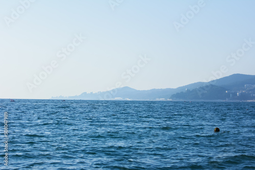 Minimalistic seascape, sea and mountains lost in a blue haze