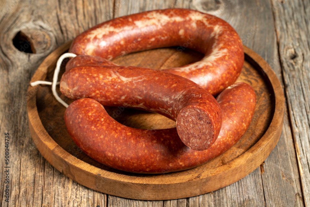 Fototapeta premium Sausage on a wooden background. Close-up spicy Turkish sausage