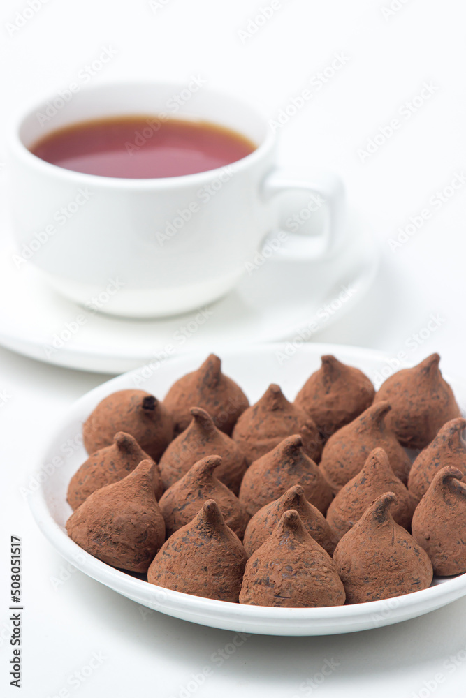 Chocolate truffle sweets on a saucer on a white background. Delicious chocolate dessert. Chocolate truffle sweets on a saucer on a white background. Delicious chocolate dessert.