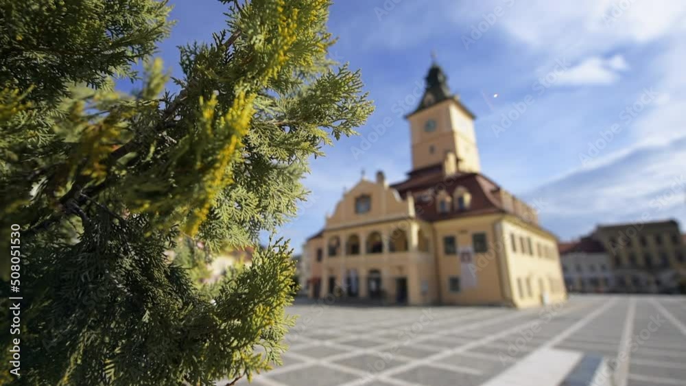 View of The Council Square in Brasov, Romania. Classic buildings, walking people, greenery View of The Council Square in Brasov, Romania. Classic buildings, walking people, greenery