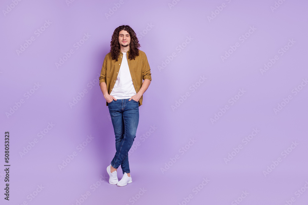 Full size photo of young man arms in pocket confident wear casual clothes isolated over purple color background Full size photo of young man arms in pocket confident wear casual clothes isolated over purple color background