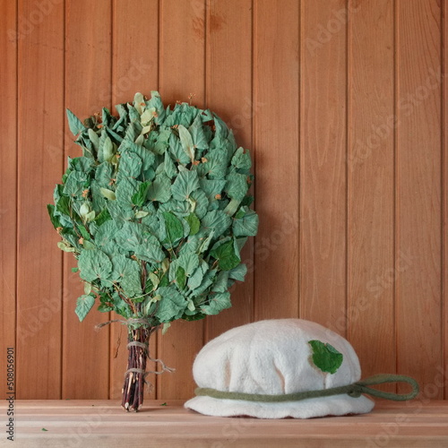 Sauna or bathhouse accessories. Broom and Hat of the shelf. Banya concept photo