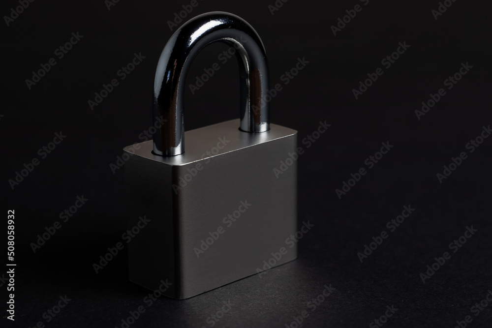 Steel padlock on the black textured background Steel padlock on the black textured background