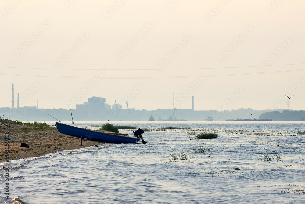 Fototapeta premium Fishing boat on the river bank on sunrise.