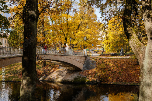 Riga, Latvia, 19 October 2021: Beautiful Bastejkalna Central Park with canals near the Latvian National Opera at autumn sunny day, bridge over water