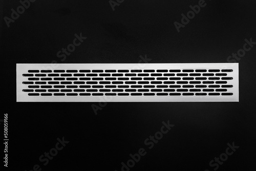 Ventilation air system modern ventilation cooling grille mounted in a black wall, close-up
