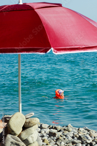 A child on a slide in a water in the summer.