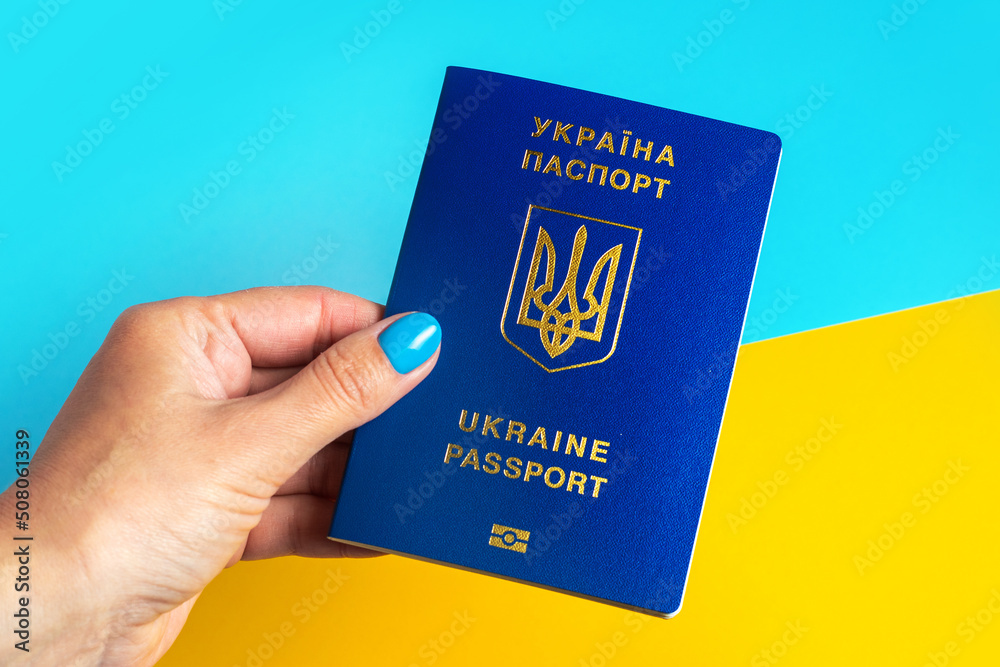 Passports of Ukraine in hand on the background of the Ukrainian flag Passports of Ukraine in hand on the background of the Ukrainian flag