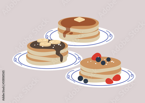 a traditional American sweet breakfast, pancakes with berries,  bananas and chocolate, and a maple syrop